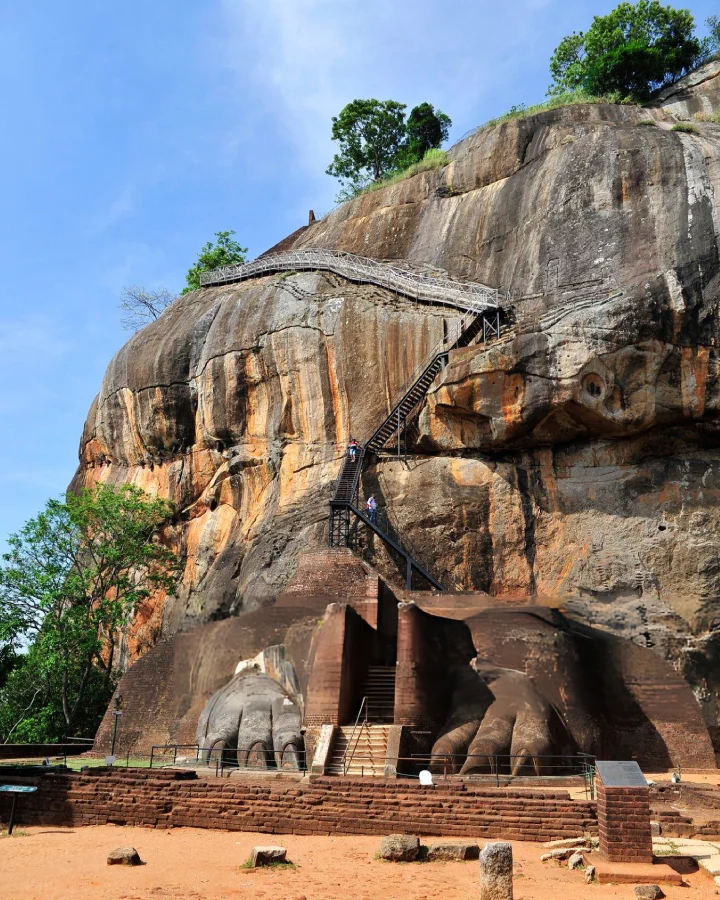 wide view of the sigiriya rock fortress with steel walkways climbing the sheer cliff face