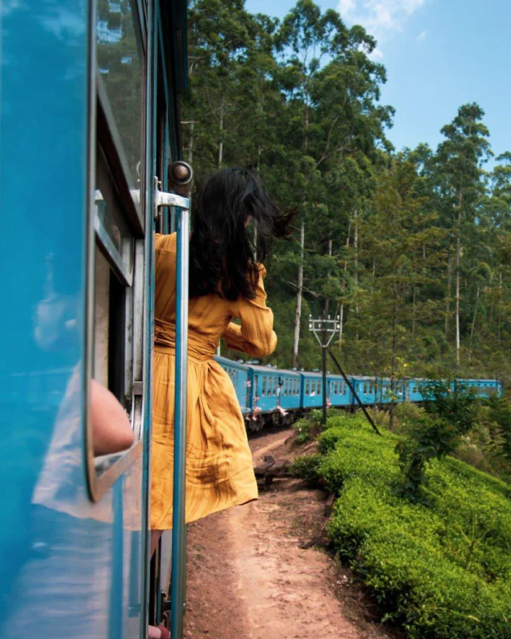 Traveler enjoying a scenic train journey through the lush hills near Kandy, Sri Lanka