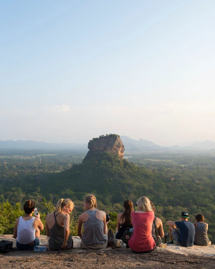 Travelers resting at Pidurangala Rock with panoramic views near Dambulla