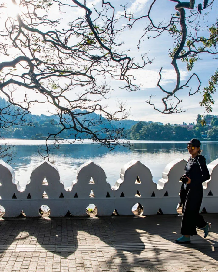 Visitor walking along the scenic pathway beside Kandy Lake in Sri Lanka