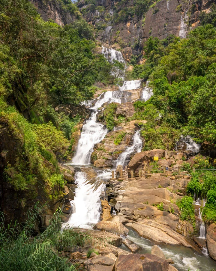 Water cascading down Ravana Falls surrounded by dense green forest near Ella, Sri Lanka