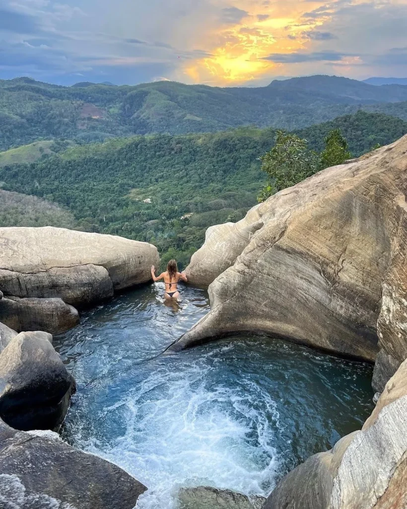 Woman swimming in a natural rock pool at Upper Diyaluma Waterfall